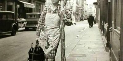 mulher levando baguete de 80 cm de comprimento, Paris, c. 1950.